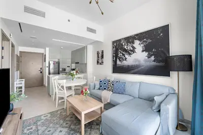 a living room with a blue couch and a table at Elegant 1-Bedroom Apartment in Dubai