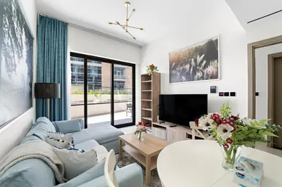 a living room with a blue couch and a tv at Elegant 1-Bedroom Apartment in Dubai