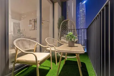 a balcony with two chairs and a table with a potted plant at Chic 2BR Stay at Creek Horizon with Pool, Gym and Prime Dubai Location in Dubai