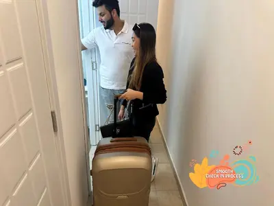 a man and a woman with a suitcase in a hallway at Vista Partition Room in Tecom Near Internet City Metro in Dubai