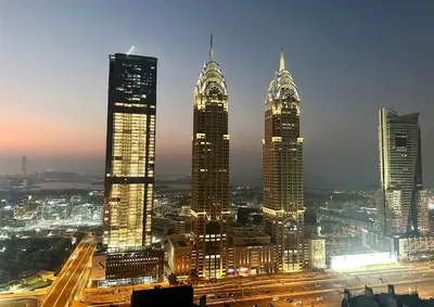 a group of tall buildings in a city at night at Cove Partition Room in Tecom Near Internet City Metro in Dubai