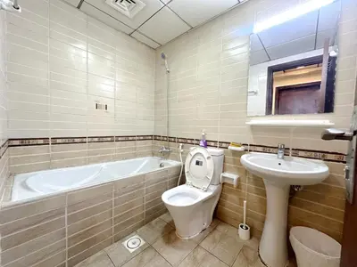 a bathroom with a tub and a toilet and a sink at Cove Partition Room in Tecom Near Internet City Metro in Dubai
