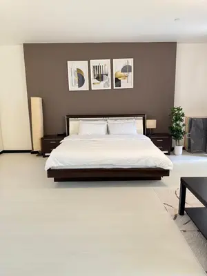 a bedroom with a large white bed with paintings on the wall at Luxury Studio in Murjan 2, JBR in Dubai