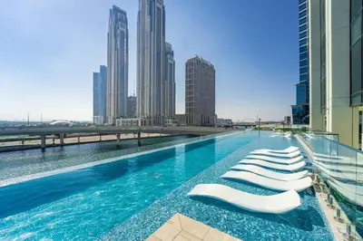 a swimming pool with chaise lounge chairs on a building at Urban Oasis by Missoni Studio in Dubai