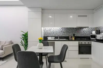 a kitchen with a table and chairs and a kitchen with a stove at Stylish 1-Bedroom in Prime Business Bay Aykon C in Dubai