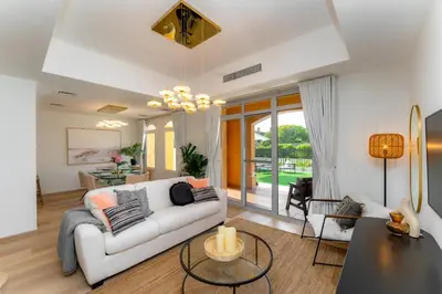 a living room with a white couch and a table at Luxury Villa in Ranches 1, on Pool and Park in Dubai