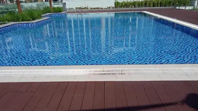 a large swimming pool with blue water at Cozy Retreat, Relax and Explore in Dubai