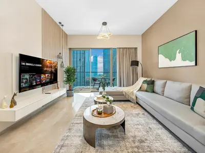 a living room with a couch and a tv at SmartStay at Grande Signature - Downtown Dubai City Views - Brand New Luxury Apartments in Dubai