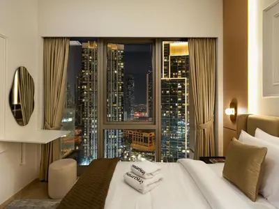 a bedroom with a large window with a city skyline at SmartStay at Grande Signature - Downtown Dubai City Views - Brand New Luxury Apartments in Dubai