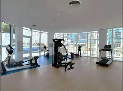 a gym with treadmills and exercise equipment in a building at 1BDR-furnished apartment, Business Bay, CANAL VIEW in Dubai