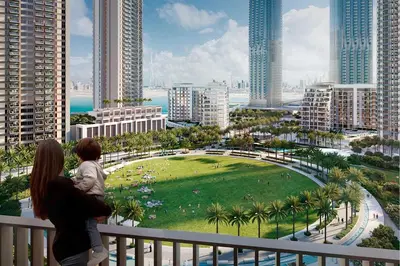 a woman and child standing on a balcony overlooking a city at Modern Home on 33rd Floor in Dubai Creek in Dubai