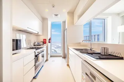 a kitchen with white cabinets and a large window at Modern Home on 33rd Floor in Dubai Creek in Dubai