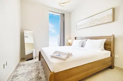 a bedroom with a large bed with a large window at Modern Home on 33rd Floor in Dubai Creek in Dubai