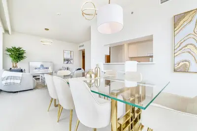 a dining room with a glass table and white chairs at Modern Home on 33rd Floor in Dubai Creek in Dubai