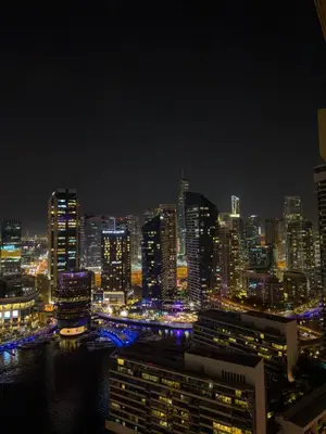 a view of a city at night with at Naseem - Elegant Coastal Retreat with Stunning Marina Views in Dubai