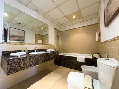 a bathroom with a toilet and a sink and a mirror at Naseem - Elegant Coastal Retreat with Stunning Marina Views in Dubai