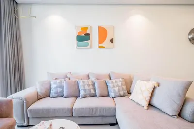 a living room with a couch with pillows on it at Luxury 2-Bed in Paramount Midtown Hotel Full Burj Khalifa Views 64th Floor Pool & Burj Views in Dubai