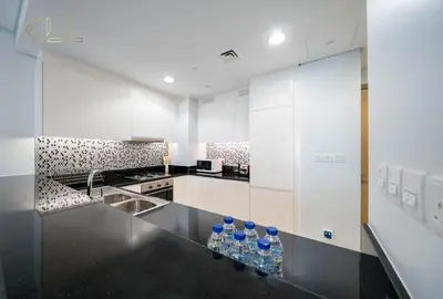 a kitchen with bottles of water on a counter at Luxury 2-Bed in Paramount Midtown Hotel Full Burj Khalifa Views 64th Floor Pool & Burj Views in Dubai