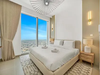 a bedroom with a large bed with a large window at Brand New Downtown unit! Bvlgari World Island View in Dubai