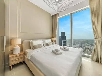 a bedroom with a large white bed with a large window at Brand New Downtown unit! Bvlgari World Island View in Dubai