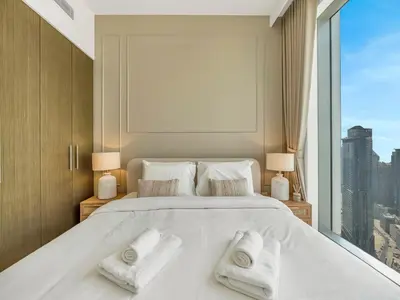 a bedroom with a large white bed with towels on it at Brand New Downtown unit! Bvlgari World Island View in Dubai