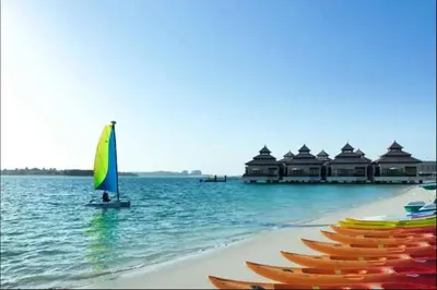 a row of boats in the water next to a beach at AWS Holiday Homes - Tranquil Stay at the Palm in Dubai