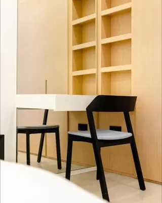 a black chair and a white desk and shelves at AWS Holiday Homes - Tranquil Stay at the Palm in Dubai