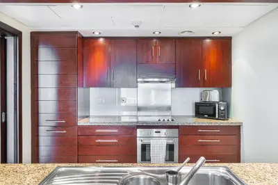 a kitchen with wooden cabinets and a stove top oven at Premium Home with Panoramic Burj Khalifa Views in Dubai