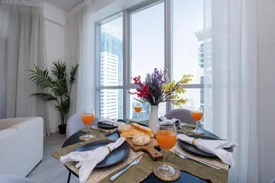 a table with a plate of food and glasses of orange juice at Stunning Interior in an deal Location in Dubai