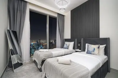 two beds in a room with a view of a city at Casa Nomad - Full Burj Khalifa & Fountain View at Luxury 4 Bed in Dubai