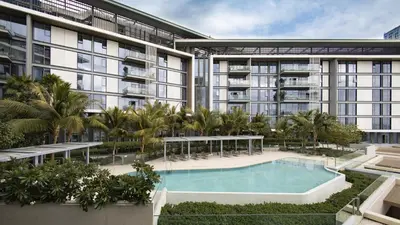 an apartment building with a swimming pool and palm trees at Bluewaters Island - Luxury 2BR with Ain View by TLRE Holiday Homes in Dubai