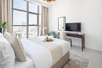 a hotel room with a bed and a desk at Frank Porter - Damac Ghalia in Dubai