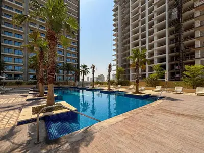 a swimming pool with palm trees and buildings at Frank Porter - Damac Ghalia in Dubai