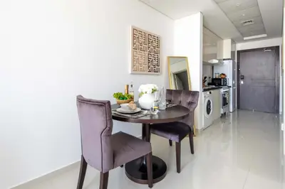 a dining room with a table and purple chairs at Frank Porter - Damac Ghalia in Dubai