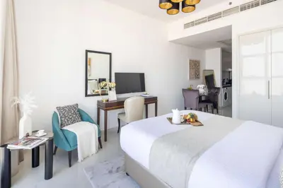 a bedroom with a bed and a desk with a computer at Frank Porter - Damac Ghalia in Dubai