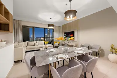 a living room with a dining table and chairs at 4BR with Spacious Balcony & Stunning Burj Khalifa Views in Dubai