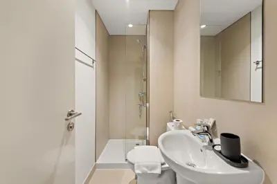 a white bathroom with a sink and a shower at 4BR with Spacious Balcony & Stunning Burj Khalifa Views in Dubai