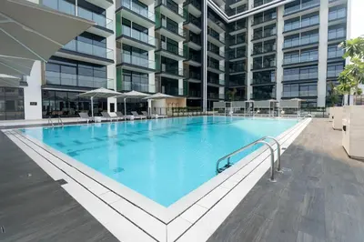 a large swimming pool in front of a building at Modern 1br In Jvc Balcony, Pool & Free Parking in Dubai