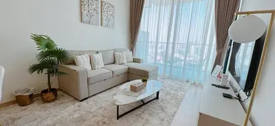 a living room with a couch and a table at Modern 1br In Jvc Balcony, Pool & Free Parking in Dubai