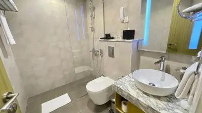 a bathroom with a white toilet and a sink at Appartement spacieux de luxe à 5mn du Burj Khalifa in Dubai
