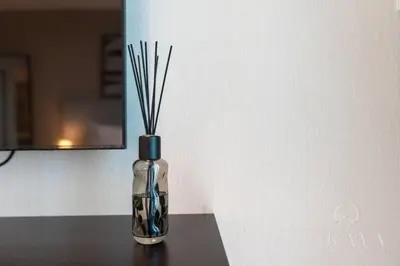 a glass bottle with sticks in it sitting on a table at Luxurious Studio In Seven Palm Hotel & Apartments in Dubai