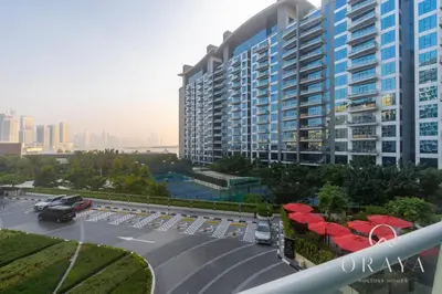 a large building with red umbrellas in a parking lot at Luxurious Studio In Seven Palm Hotel & Apartments in Dubai