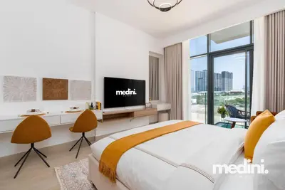 a hotel room with a bed and a tv at Studio - Azizi Riviera 37 in Dubai