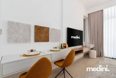a living room with a desk and two chairs at Studio - Azizi Riviera 37 in Dubai