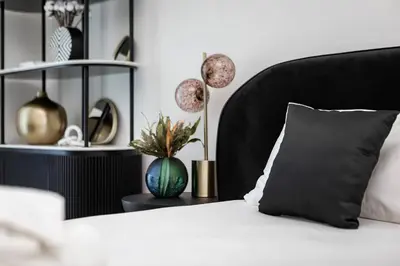 a bed with a black headboard and a pillow on it at Sophisticated Binghatti Canal in Dubai
