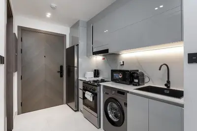 a kitchen with a washer and a sink and a stove at Sophisticated Binghatti Canal in Dubai