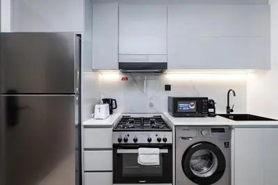 a kitchen with a stove and a refrigerator at Sophisticated Binghatti Canal in Dubai