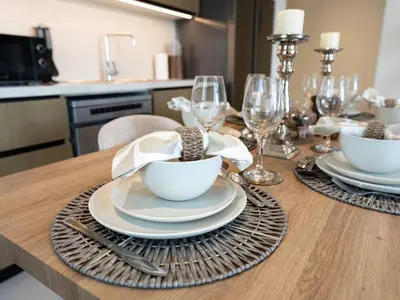a dining room table with plates and bowls and glasses at 2BR-Downtown Apartment- 10 Min Walk to Dubai Mall in Dubai