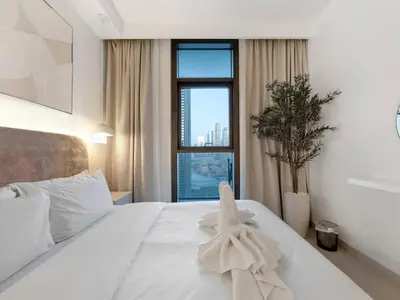 a bedroom with a white bed with a window at 2BR-Downtown Apartment- 10 Min Walk to Dubai Mall in Dubai