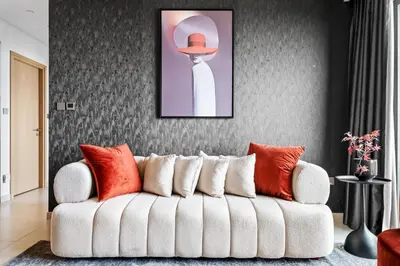a living room with a white couch with orange pillows at Cosmic Sky Suite High floor 1BR- Dubai Mall Access by Maxx Value Homes in Dubai